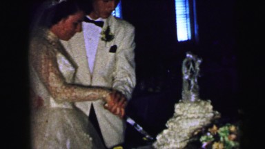 1964: just married couple is cutting their wedding cake CAMDEN, NEW JERSEY