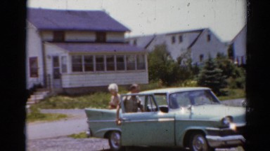 1964: couple getting out of car in driveway CALIFORNIA