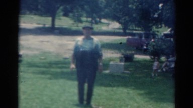 1964: an older person standing in a rural area with tables and benches to eat