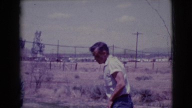 1968: a man and two boys in the yard who appear to be playing marbles