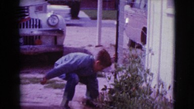 1968: a boy taking some object from the bushes and another one approaches him