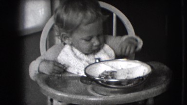 1942: young child sitting in high chair throwing playing with food NEW YORK