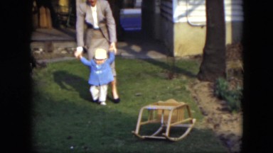 1951: Mother Helping Beautiful Child Walk on Grass in Cleveland, Ohio