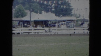 1951: horses and riders are performing at a local fair with colorful tents