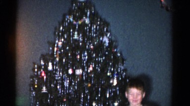 1962: a boy is standing in front of a christmas tree