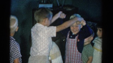 1962: children smiling laughing excited playing london bridge by television