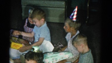 1962: children at a birthday party watching a little boy open gifts CATSKILL