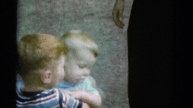 1962: a boy carries his younger baby brother around a zoo