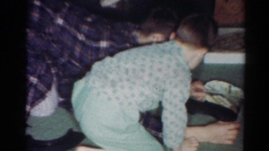 1964: father son playing on floor with car on track CALIFORNIA
