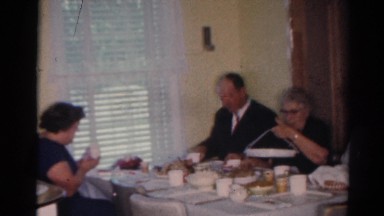 1964: adults and children eating plenty and cheerful around two separate tables