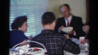 1964: vintage video of six adults enjoying a meal together at a table.