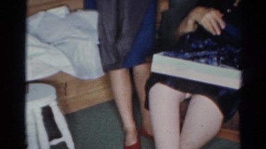 1964: three girls grandma opening clothes gifts showing them to each other