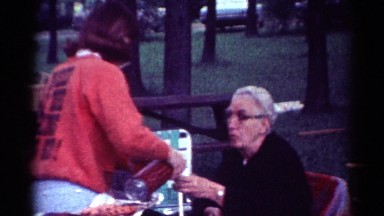 1964: a family seated outdoors in lawn chairs enjoying a picnic CALIFORNIA