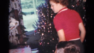 1964: kids in examining various gifts from under a christmas tree CALIFORNIA