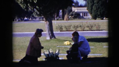1968: a family is sitting on the grassy ground and praying CLARKSDALE, ARIZONA