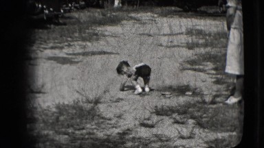 1942: Child Trying to Walk on the Sand Watched by a Woman and a Little Girl