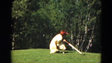1949: woman positions golf ball in preparation to hit ball into hole MINNESOTA