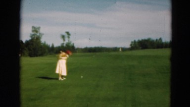 1949: a woman in a dress on a golf course hitting a golf ball MINNESOTA