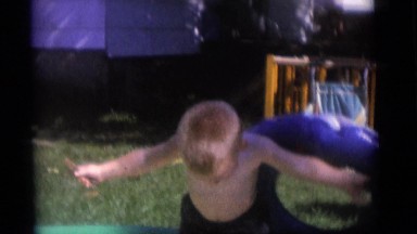 1965: A Little Boy Having Fun Trying to Put on His Inflatable Liferaft