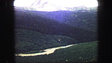 1967: view of a big natural valley and snowy mountains from a high point of view