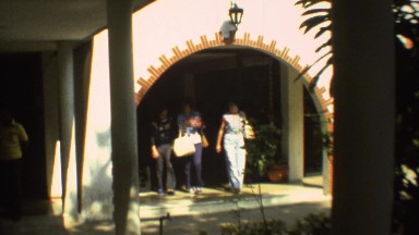 1973: two women and a man exiting a building out into the sunlight MEXICO