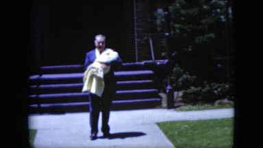1951: Grandfather Walking Down Church Steps Carrying Baby
