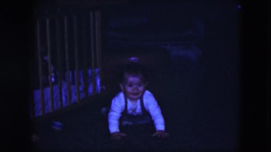 1951: a little baby in suspenders on the floor attempting to crawl CLEVELAND