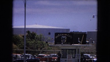 1966: A Parking Lot With a Guard Inside a Fence California