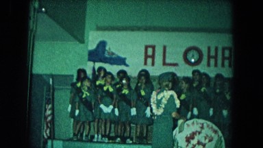 1966: a group of children sitting under an "aloha" sign CALIFORNIA
