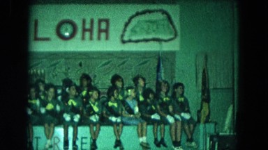 1966: a group of girl scouts sitting under an "aloha" sign CALIFORNIA