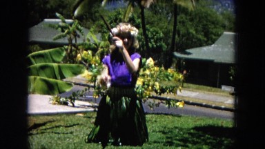 1966: a young girl in hawaiian attire hits sticks together CALIFORNIA