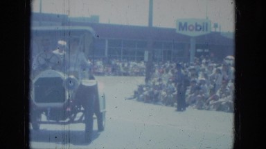1966: Police Vehicle with Department Sign Drives Down Street