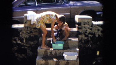 1966: sisters having fun bathing their dog together HAWAII