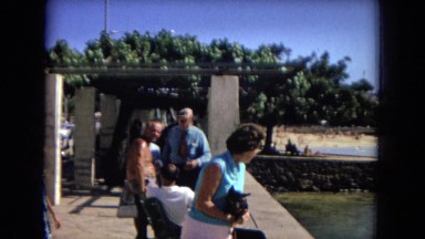 woman holding small dog looking out over ocean HAWAII