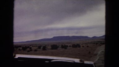 1967: a beautiful desert and rugged mountain ridgeline with a cloudy blue sky