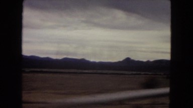 1967: driving in a large desert on a straight road under dark clouds ARIZONA