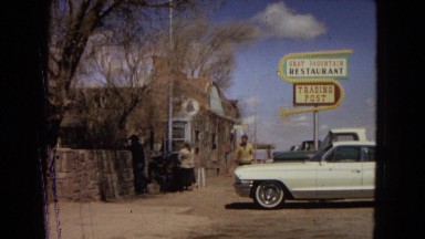 1967: man walking in front of old restaurant and car. women entering phone