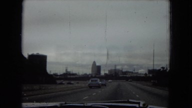 1967: car driving on highway passing under freeway sign CALIFORNIA