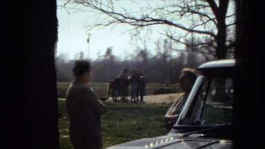 1967: men standing outdoor besides a car having a conversation