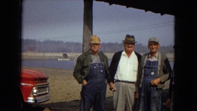 1967: four men standing outdoor by a truck near a body of water ARIZONA