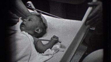 1941: view of a newborn receiving care in a hospital from nurses