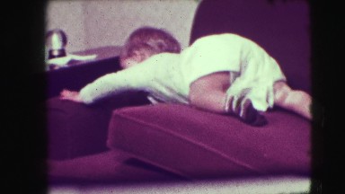1942: baby crawls over couch cushions towards fragile object NEW YORK