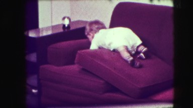 1942: cute baby is trying to catch an object over the couch NEW YORK