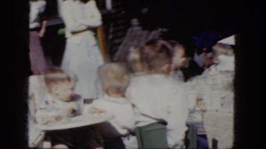 1964: children seated at a table at a birthday party while moms keep watch