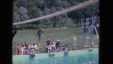 1965: Several People Make Jumps Off a Diving Board Into a Swimming Pool
