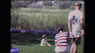 1967: children are staying around a baby sitting on the grassy ground TUCSON