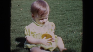 1967: children at an outdoor party one small child is restless and tries to eat