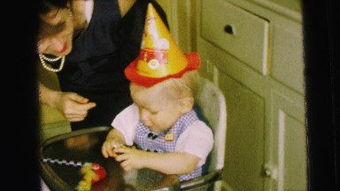 1964: A Mother Tending to a Birthday Boy Wearing a Party Hat