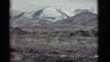 1964: view of a mountain range from a distance over hills and valleys