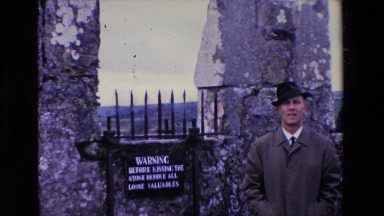 1969: a well dressed man standing in front of a stone fence waving IRELAND